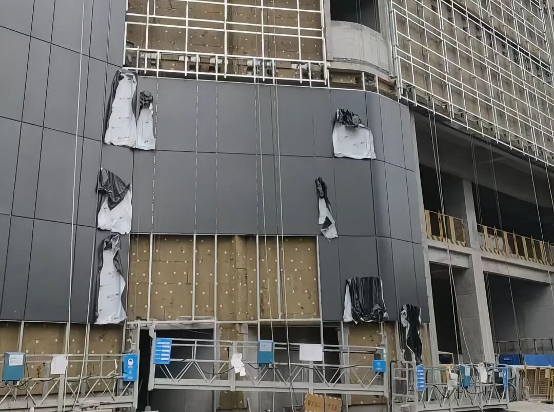 yisosail commercial curtain wall facade insulation Yisosail non-combustible rock wool insulation materials being installed on a high-rise commercial building curtain wall facade.